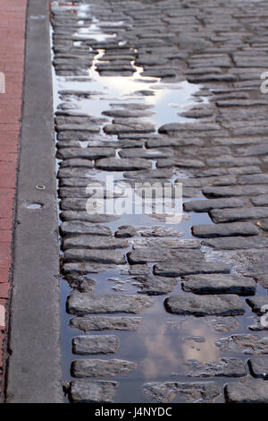 Eine reflektierende Kopfsteinpflaster Pfütze auf River Street entlang der berühmten Riverwalk in Savannah, Georgia Stockfoto