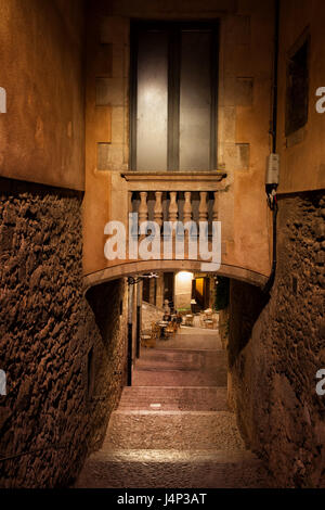 Von Girona bei Nacht, mittelalterliche Altstadt, kleinen Raum auf winzige Brücke zwischen zwei Gebäuden, gepflasterten engen Gasse mit Treppen im alten jüdischen Viertel, C Stockfoto