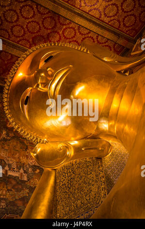 Nahaufnahme der riesigen goldenen Statue im Tempel des liegenden Buddha in Bangkok, Thailand Stockfoto
