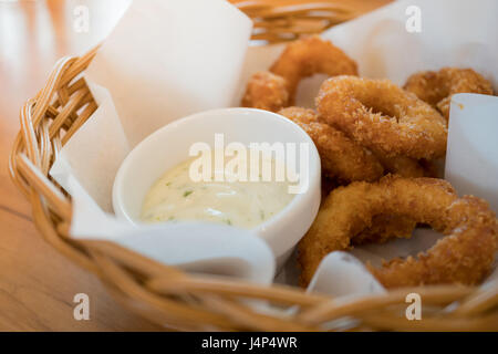 Fritierter Tintenfisch-Ringe mit Remoulade im Weidenkorb Stockfoto