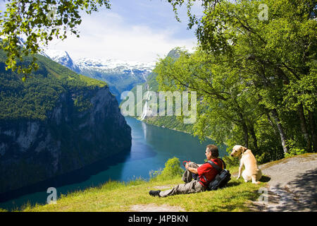 Norwegen, Geirangerfjord, Ansicht, Wasserfälle sieben Schwestern, Mann, Hund, sitzen, kein Model-Release Stockfoto