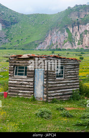 Ein Blockhaus steht allein in einer Bergwiese im hohen Kaukasus von Georgia Stockfoto