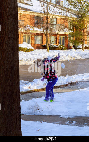 Kleines Mädchen Schneeschaufeln auf Basislaufwerks Weg. Kind mit Schaufel spielen im Freien in der Wintersaison. Stockfoto