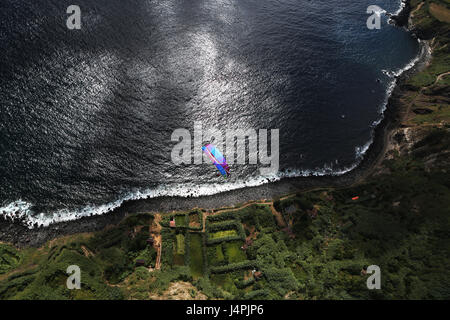 Eine weibliche Gleitschirmpilot während der 22. Azoren Paragliding Festival in São Miguel, Azoren, Portugal fliegen. Stockfoto