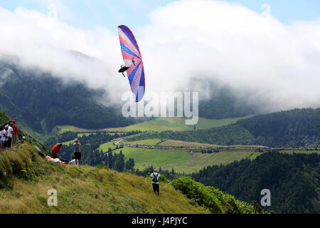 Ein Paragliding Acro Piloten fliegen während der 22. Azoren Paragliding Festival am Lagoa Das Sete Cidades in São Miguel, Azoren, Portugal. Stockfoto