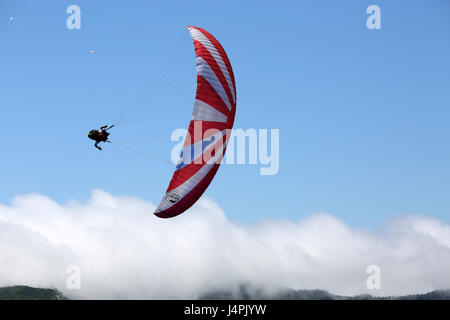 Ein Paragliding Acro Piloten fliegen während der 22. Azoren Paragliding Festival am Lagoa Das Sete Cidades in São Miguel, Azoren, Portugal. Stockfoto