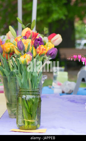 Eine Reihe von Blumensträußen in Mason Gläser auf einem Bauernmarkt Stockfoto