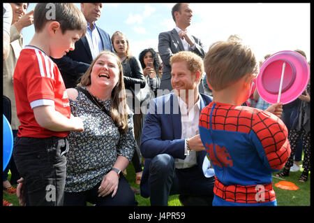 Prinz Harry spricht mit Lee Rigbys Frau Rebecca und seinem Sohn Jack (links, im roten Fußball oben) während einer Tee-Party im Buckingham-Palast veranstaltet von Prinz Harry und der Herzog und die Herzogin von Cambridge für die Kinder der Streitkräfte Männer und Frauen, die für ihr Land gestorben. Stockfoto