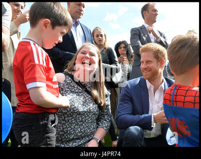 Prinz Harry spricht mit Lee Rigbys Frau Rebecca und seinem Sohn Jack (links, im roten Fußball-Top) während einer Teeparty im Buckingham Palace, veranstaltet von Prinz Harry und dem Herzog und der Herzogin von Cambridge, für die Kinder von Männern und Frauen der Streitkräfte, die im Dienste ihres Landes starben. Stockfoto