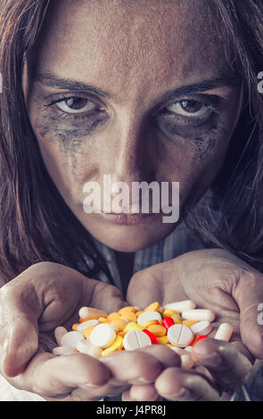 Pillen in Frauenhand auf dunklem Hintergrund. Pillen im Fokus Stockfoto