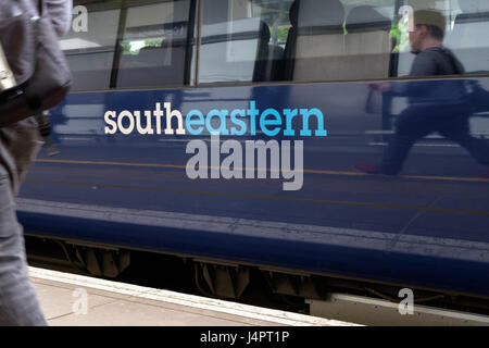 Südöstlichen Zug am internationalen Bahnhof Ashford Passagiere Reflexion Leute warten. Südöstlichen Logo auf dem Zug. Ashford, Kent, Großbritannien Stockfoto