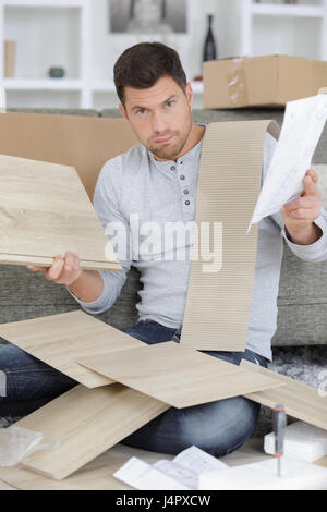 frustriert Mann Zusammenstellung Selbstmontage Möbel Stockfoto