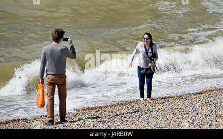 Brighton, UK. 14. Mai 2017. Eine junge Dame lacht, als sie von einer Welle beim Paddeln auf Brighton Beach bei schönem sonnigen Wetter mit Temperaturen über 20 Grad Celsius im Laufe des Tages erreichen ertappt wird. Bildnachweis: Simon Dack/Alamy Live-Nachrichten Stockfoto