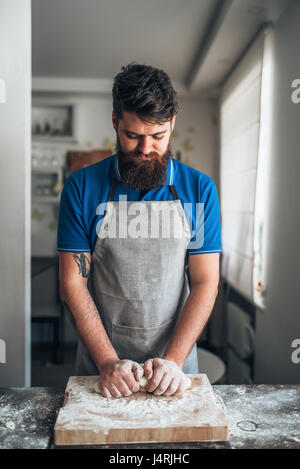 Baker Hände kneten den Teig mit Mehl. Brot-Vorbereitung. Hausgemachte Backwaren Stockfoto