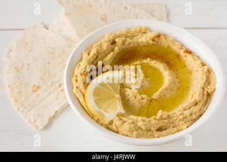Hummus mit Gewürzen und Zitrone im selektiven Fokus Schüssel weiß Stockfoto