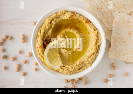 Hummus mit Gewürzen und Zitrone im selektiven Fokus Schüssel weiß Stockfoto