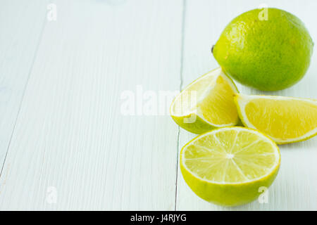 Schnitt und ganze Limetten auf weißer Holztisch kopieren Raum selektiven Fokus Stockfoto