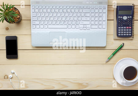 Top View Notebook, Bleistift, schwarzer Kaffee, Kaktus, schauen, Laptop, stationär, Stift, Taschenrechner auf Office Schreibtisch-Hintergrund. Stockfoto