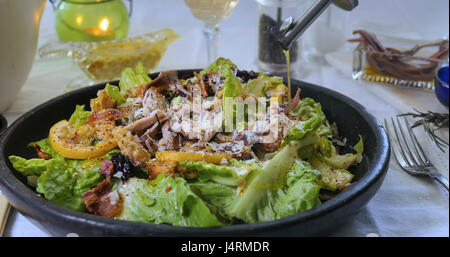 Olivenöl in Strömen über eine köstliche Caesar Salat Stockfoto