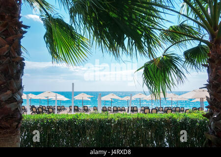 Reihe von Sonnenschirm Sonnenschirme am Strand. Ruhigen Blick auf das Mittelmeer. Sonniger Tag mit strahlend blauen Himmel. Minimalistische Szene. Ort: Turke Stockfoto