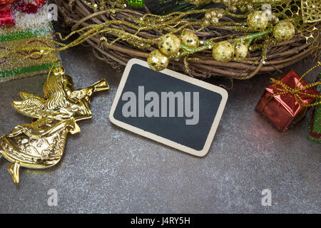 Leere Tafel, Weihnachtskranz und Ornamente auf rustikale Fliese Hintergrund Stockfoto