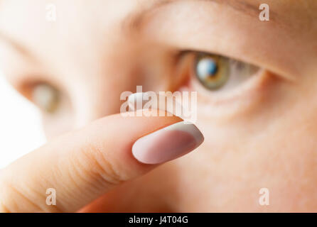 Weibliche Auge und Kontaktlinse. Finger im Fokus Stockfoto