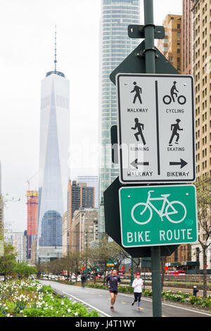 Läufer, die auf Hudson River Greenway mit dem One World Trade Center und Lower Manhattan im Hintergrund, New York, USA Stockfoto