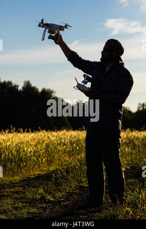 Operator hielt Drohne und Controller in seinen Armen auf natürlichen Hintergrund Stockfoto