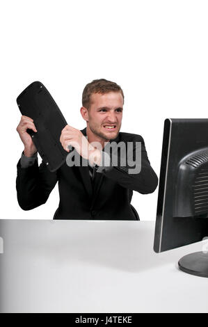 Verärgerter Mann mit einem Desktop-Computer für Unternehmen Stockfoto