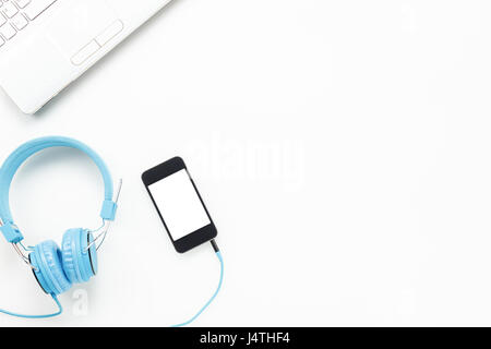 Ansicht von oben Zubehör Büro desk.smartphones Kopfhörer Schlüsselbrett Laptop auf weißem Hintergrund mit Textfreiraum. Stockfoto