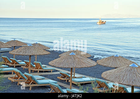 Parsols und Sonnenliegen auf Kamari Strand Kamari, Santorini, Griechenland Stockfoto