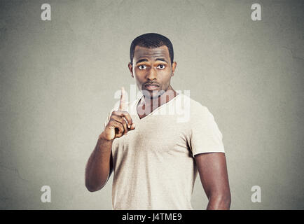 Closeup Portrait junger Mann nach oben mit der Idee, Lösung, mit dem Zeigefinger Nummer eins isolierte graue Wand Hintergrund zeigt. Stockfoto