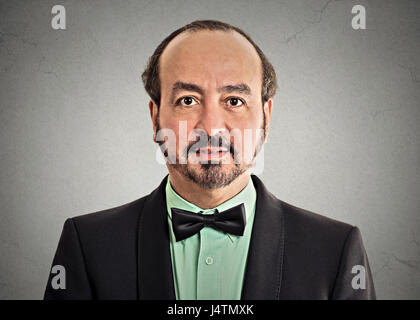 Kopfschuss Porträt Reife Herren gut aussehender Mann in eleganten schwarzen Anzug tragen Fliege auf graue Wand Hintergrund isoliert. Positiven Gesichtsausdruck Stockfoto