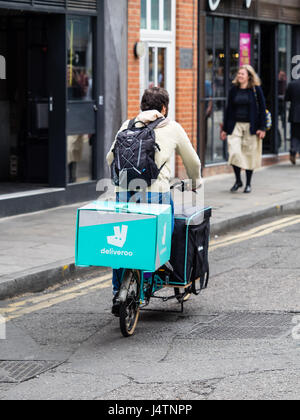 Deliveroo Essen Lieferung Kurier liefert Essen auf eine große Kapazität Lastenfahrrad. Stockfoto