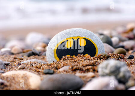 Paphos, Zypern - 22. November 2016 Kiesel mit gemalten Schild Batman am Strand mit Sand und Steinen. Stockfoto