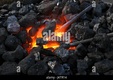 Nahaufnahme eines Ofens, Metall wird in der Schmiede auf Kohlen mit heiße brennende Kohle beheizt. Stockfoto