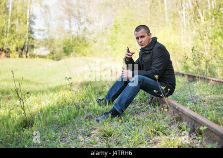 Mann mit Zigarette und Flasche Stockfoto