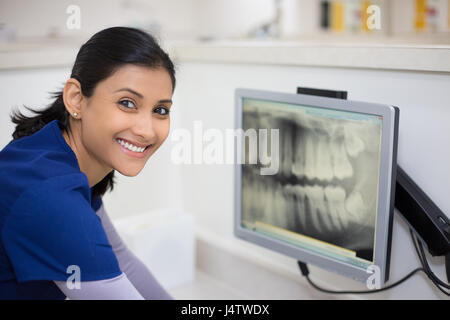 Closeup Portrait von Alliierten zahnmedizinische Heilberufe in blau scheuert Prüfung Zahnröntgen auf Bildschirm, isolierte Zahnarztpraxis Stockfoto