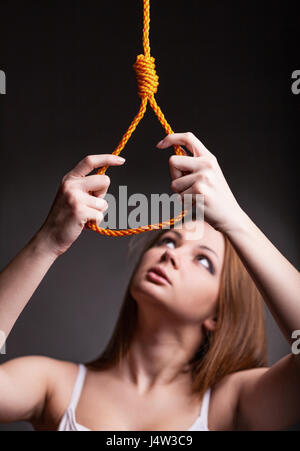 Junge Frau will auf einem dunklen Hintergrund hängen Stockfoto