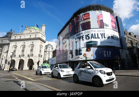 Im Piccadilly Circus werden drei Cabrio-Smart-Autos zu sehen sein, um Yonda, Londons erstes selbstfahrenes Sightseeing-Erlebnis, zu starten. Stockfoto