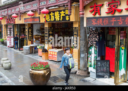 Zhenyuan, Guizhou, China.  Straßenszene in modernen Zhenyuan, mit offener Vorderseite Geschäften. Stockfoto