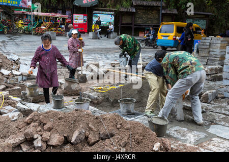 Zhenyuan, Guizhou, China.  Frauen arbeiten als Teil einer Straße-Reparatur-Crew. Stockfoto