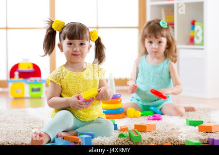 Kleine Kinder spielen mit bunten Spielzeug auf dem Boden zu Hause oder den Kindergarten. Lernspiele für Kinder. Stockfoto