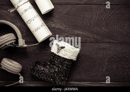 Draufsicht Weihnachten Musik Notizpapier mit Weihnachtsdekoration und Kopfhörer auf Holztisch Hintergrund. Erschaffen Sie dieser Hinweis Notenpapier selbst. Stockfoto