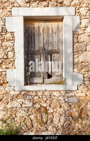 sehr alte Fensterläden vor Fenster im antiken griechischen Gebäude aus Stein Stockfoto