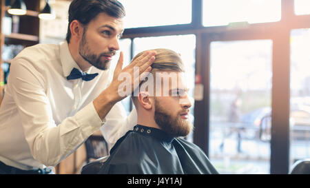 Junger Mann im Barbershop Haar-Pflege-Service-Konzept Stockfoto