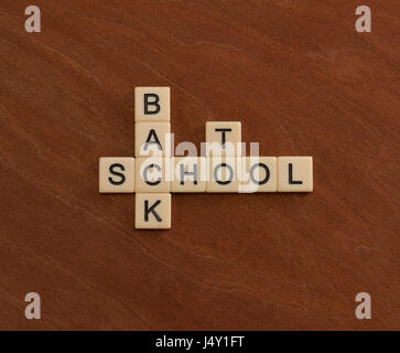 Kreuzworträtsel mit Worten Back To School. Bildungskonzept. Elfenbein Fliesen mit Großbuchstaben auf Mahagoni Brett. Stockfoto