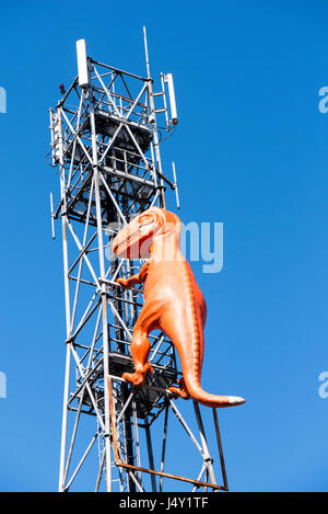 Orange Kunststoff Dinosaurier auf eine Antenne Turm Stockfoto