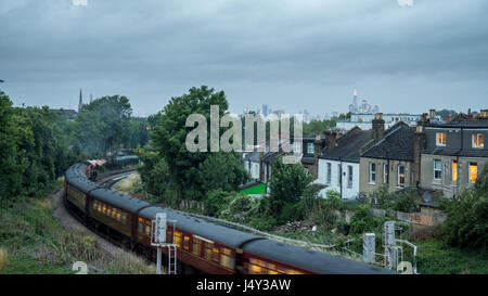 London, England - 26. Juli 2015: Ein Dampfzug, am Abend beleuchtet schlängelt sich durch die South London Vorstadt von West Norwood und Tulse Hill, mit sk Stockfoto