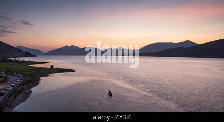 Die Berge der Halbinsel Ardnamurchan sind Silhouette gegen den Sonnenuntergang über den Loch Linnhe von Ballachulish Brücke gesehen. Stockfoto